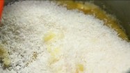 Wsypywanie wiórków kokosowych do masła