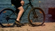 Jazda rowerem po piachu nad brzegiem jeziora