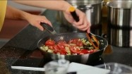 Dodawanie pomidorów do smażonego bakłażana