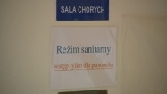 Kartka "Reżim sanitarny" wywieszona na drzwiach sali chorych