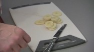 Wrzucanie plasterków banana do pojemnika z owocami