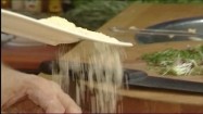 Dodawanie tartego parmezanu do ciasta na gnocchi